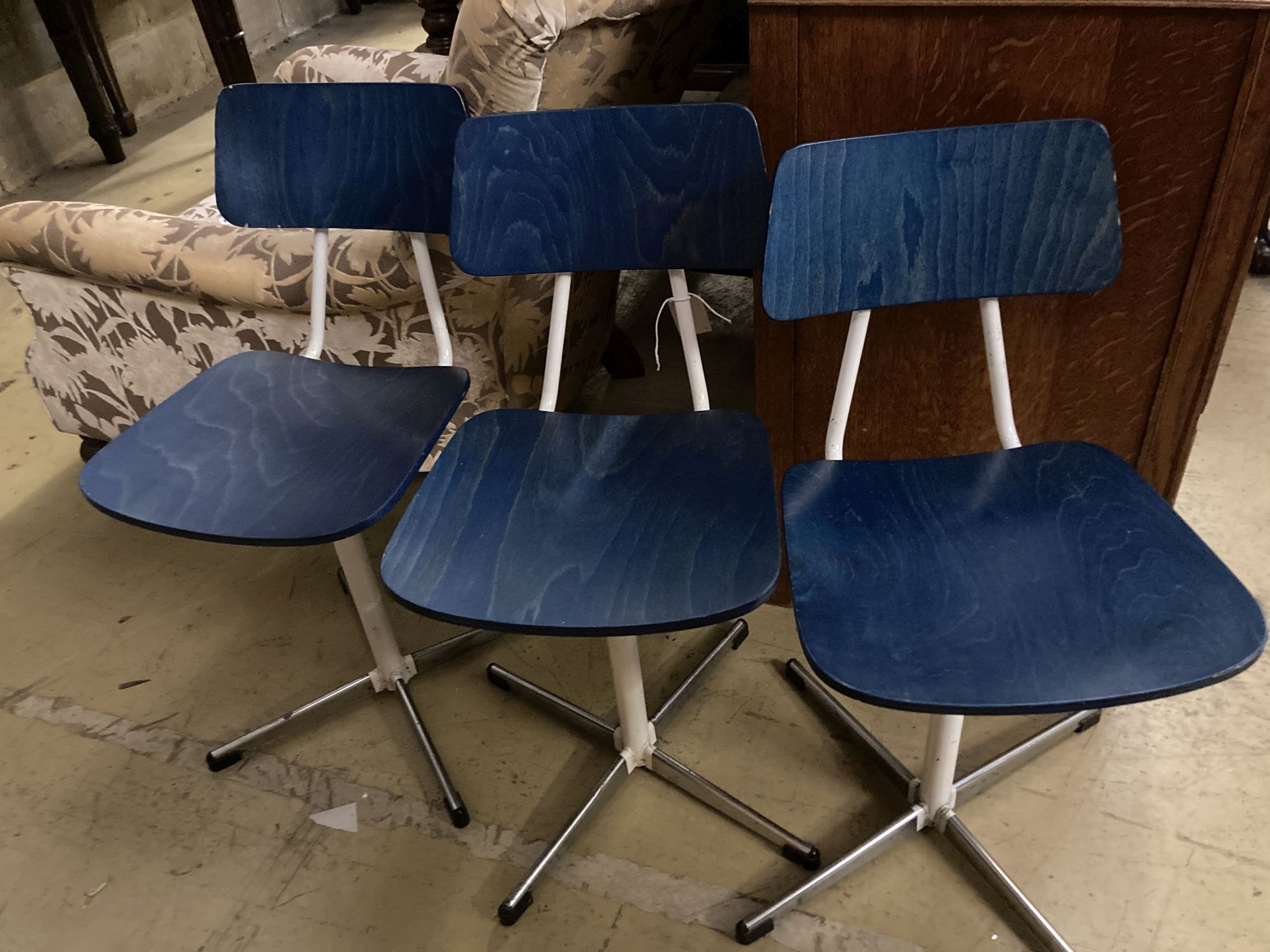 A set of three mid century stained beech and metal childs swivel chairs